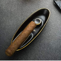 Cigar and humidor on a textured surface. Vape Dokha UAE