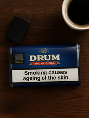 DRUM rolling tobacco pack on a wooden surface with a cup of coffee and lighter. | Vape Dokha UAE