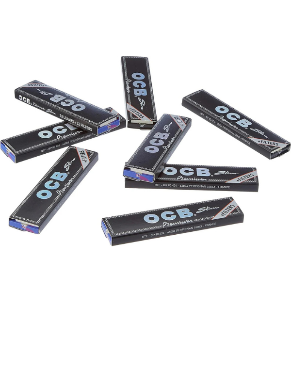 OCB rolling paper packs scattered on a white background
