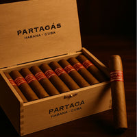 Open wooden box of Partagás cigars with a single cigar on a dark background .Vape Dokha UAE