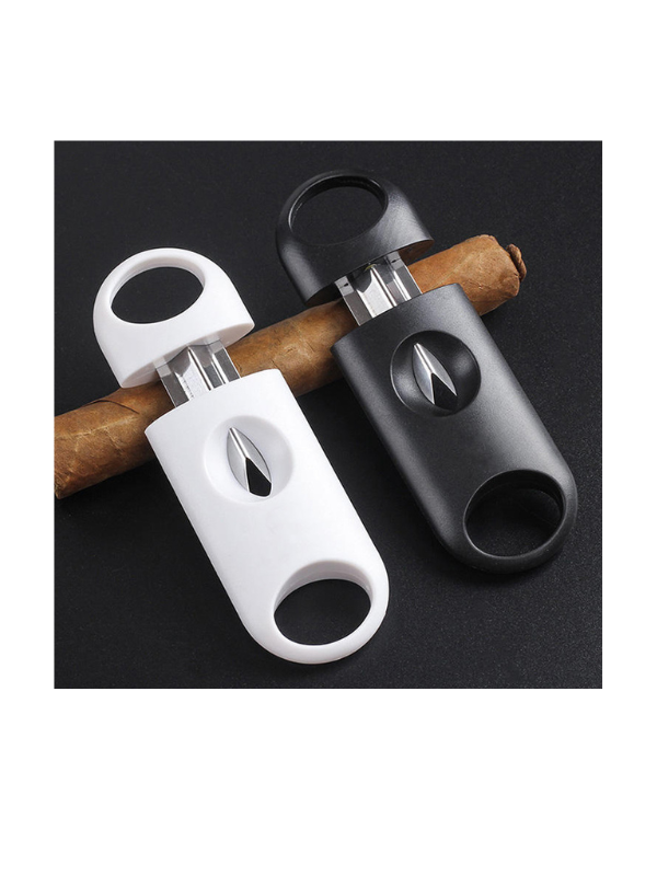 Two cigar cutters, one white and one black, on a black background with cigars. vape dokah UAE