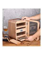 Wooden humidor with glass door on a wooden table, with a glass of wine and a lighter in the background. Vape Dokha UAE